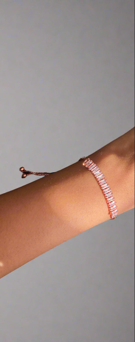 Close-up of a wrist wearing a pink beaded bracelet against a textured black background