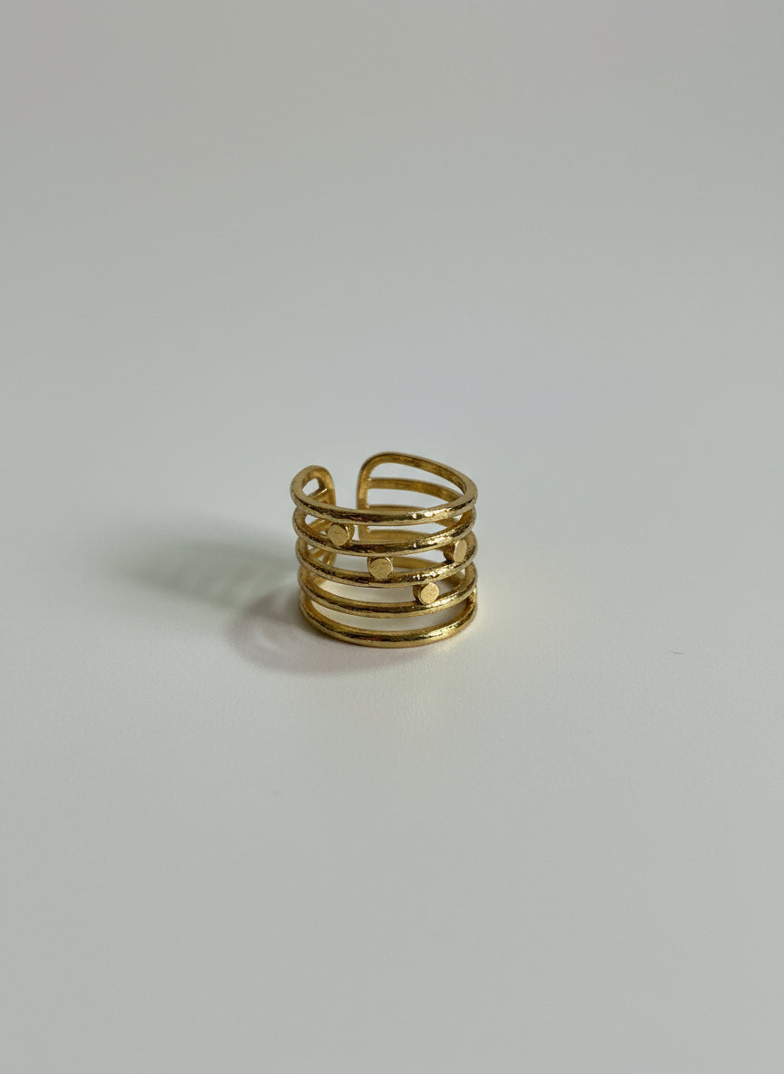 Close-up of multi-band textured gold ring featuring hammered detailing and open adjustable design