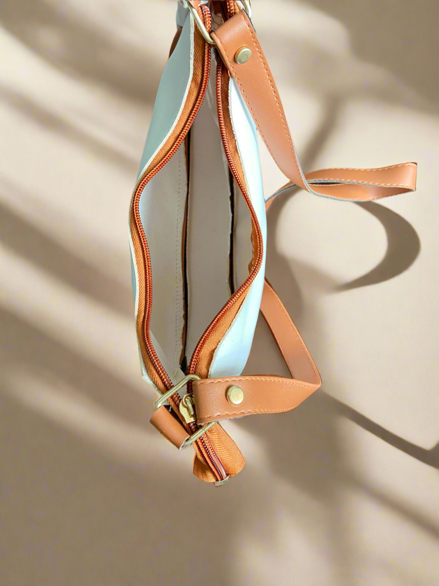 Tan leather strap with gold hardware on a beige background