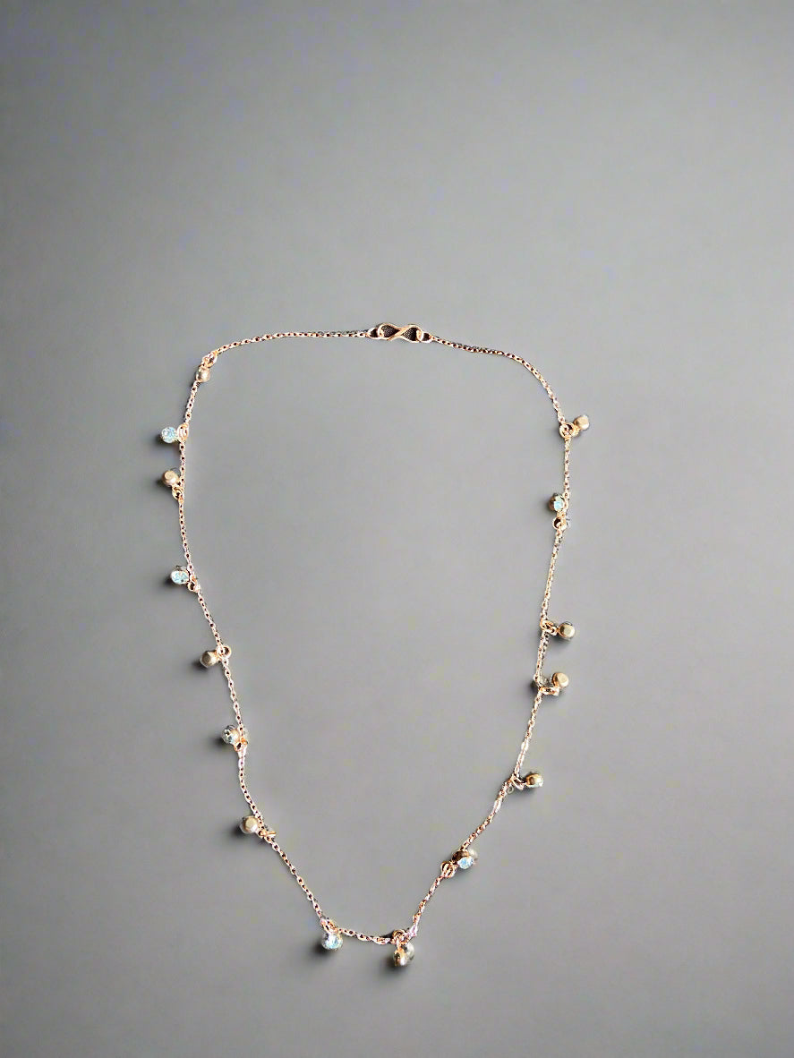 Delicate necklace with small beads on a dark fabric background