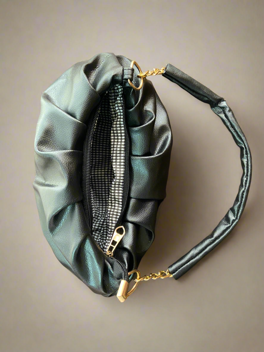 Black bag with gold zipper pull on a beige background