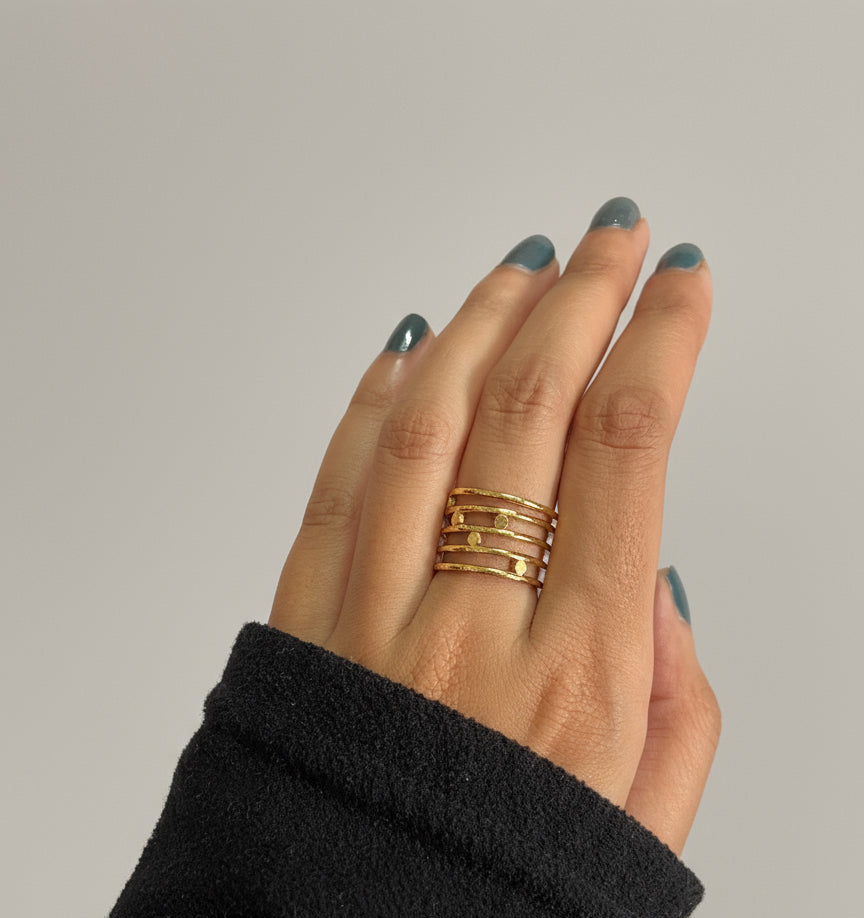 Close-up of multi-band textured gold ring featuring hammered detailing and open adjustable design