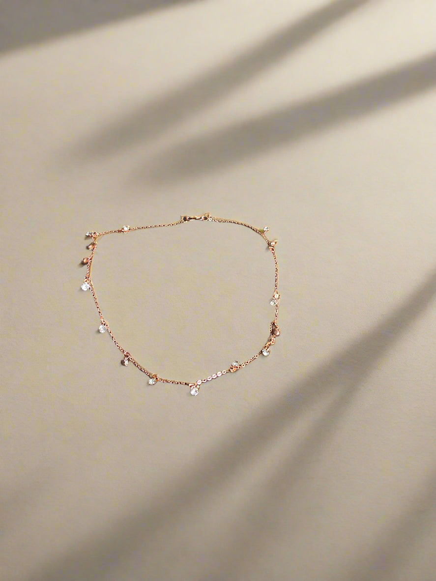 Rose gold necklace on a brown fabric surface